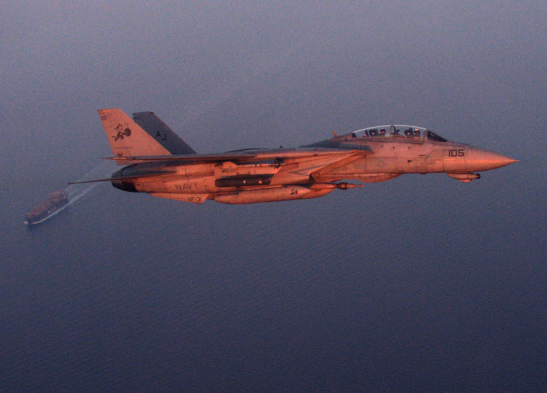 US Navy 051019-N-5088T-002 An F-14D Tomcat banks over an oil tanker while conducting a sunset maritime security mission over the Persian Gulf